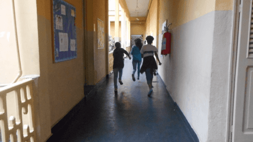 Crianças correndo pelo corredor da escola